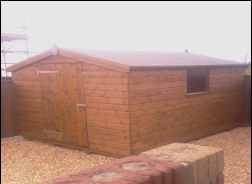 A timber apex shed with a door and window