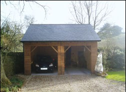 An open-bay oak-style car port with a slate-look roof