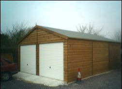 A double timber garage with white up-and-over doors